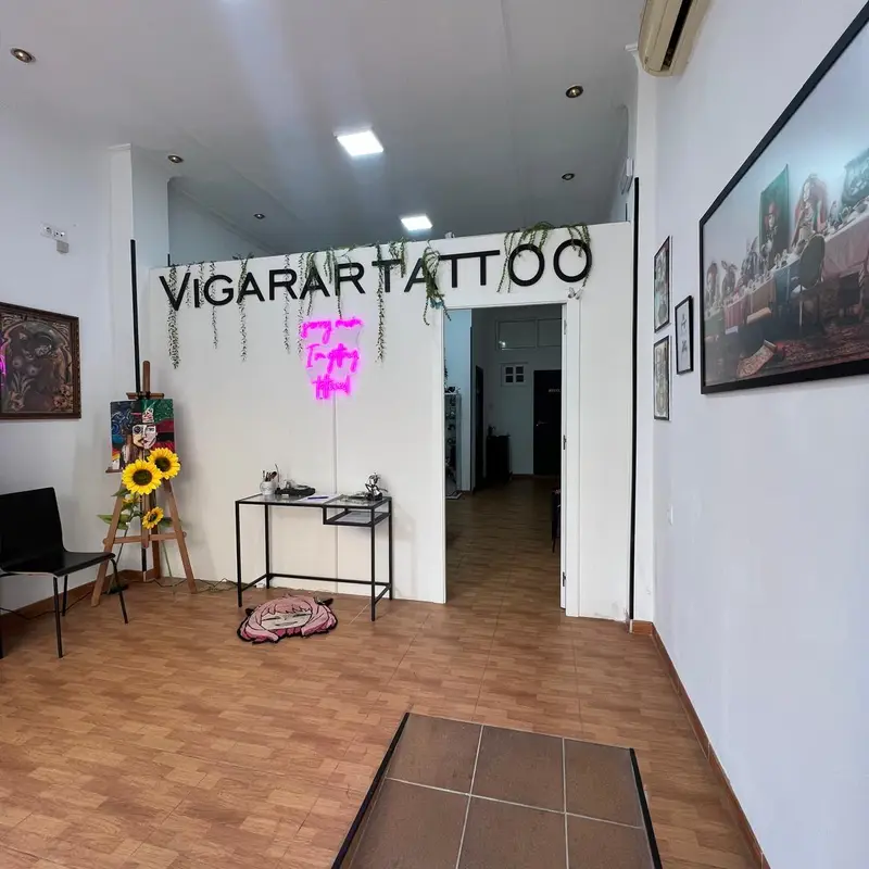 Interior del estudio de tatuajes Vigarartattoo, espacio luminoso y decorado con arte y plantas.