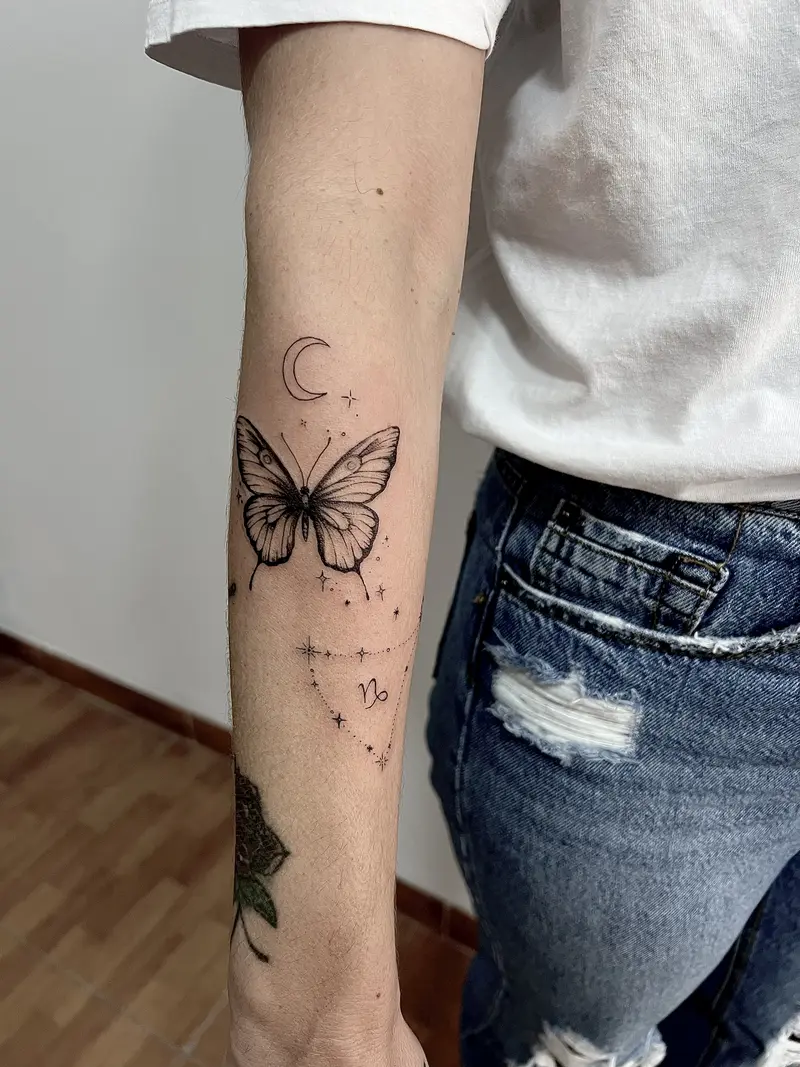 Mariposa con luna creciente y detalles astrales, estilo blackwork.