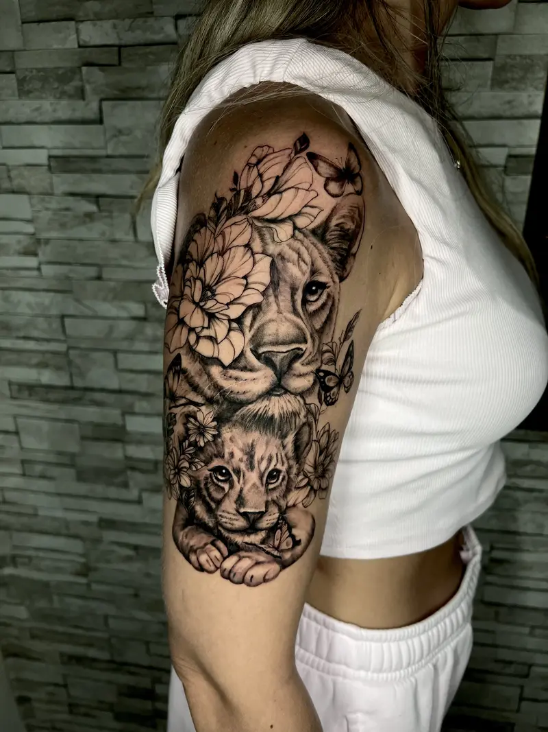 León con cachorro y flores en composición realista, tinta negra.