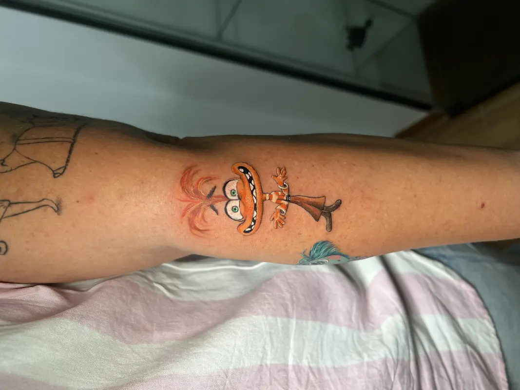 Personaje caricaturesco con gran bigote naranja, ojos verdes y traje, estilo dibujo humorístico.