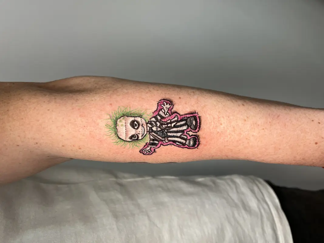 Personaje estilo Beetlejuice en versión chibi, realizado como parche bordado con contorno cosido.