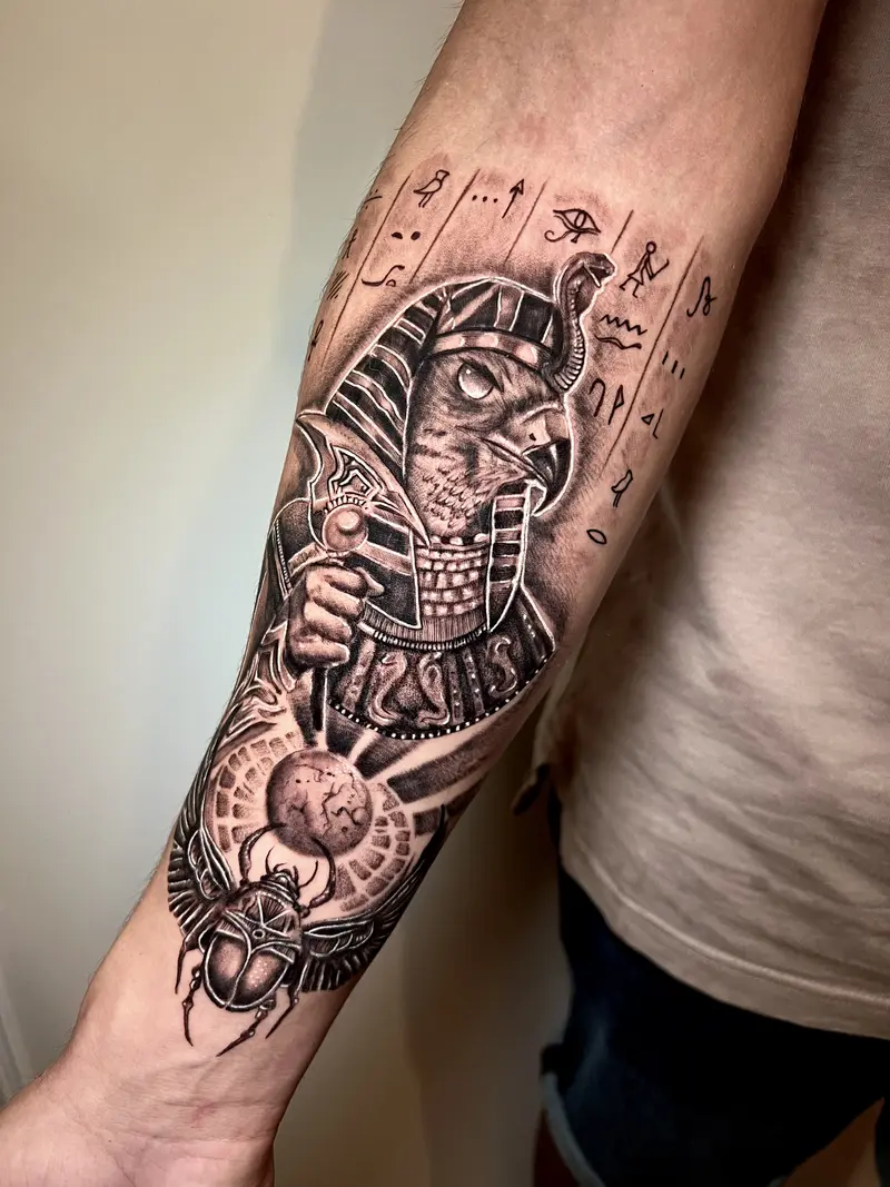 Tatuaje de temática egipcia con un faraón, símbolos antiguos y composición detallada en blanco y negro.