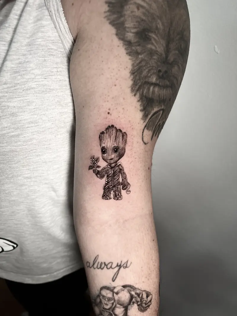 Pequeño tatuaje a color del personaje Groot, con estilo tierno y detalles delicados.